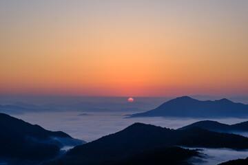 Scenic view of morning fog and mist against sky during sunrise