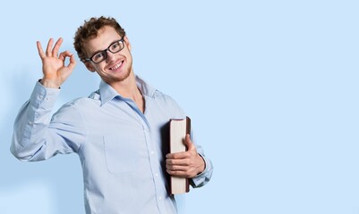 Young  happy man student holding a book