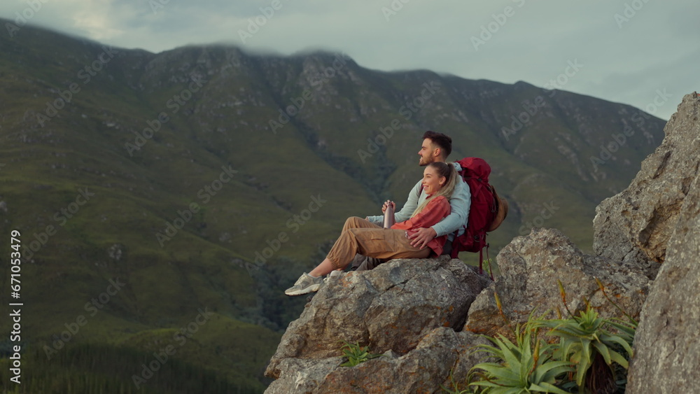 Sticker Hiking, mountains and view, couple relax on outdoor adventure and peace in nature with romance. Trekking, climbing and love, man and woman with view of natural landscape sitting on rocks together.