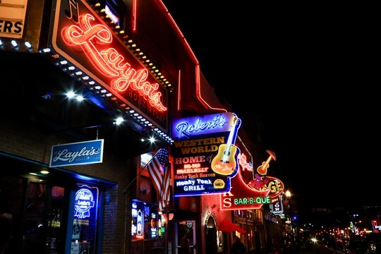 Country Music bars (Honky Tonk) on Broadway Ave Nashville. Night time crowds visiting the neon lighted downtown street. Nashville, Tennessee, USA - October 1