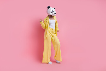 Full size portrait of excited unusual 3d panda mask girl have fun dancing empty space isolated on pink color background © deagreez