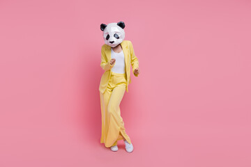 Full body portrait of excited charismatic 3d panda mask lady dance empty space isolated on pink...