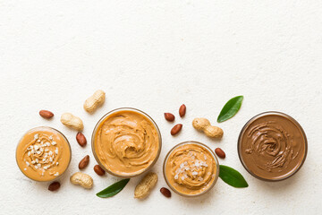 Glass jar with peanut butter on table background, top view space for text and close up