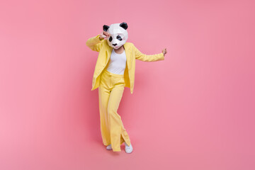 Full size portrait of cool strange 3d panda mask girl enjoy dancing empty space isolated on pink...