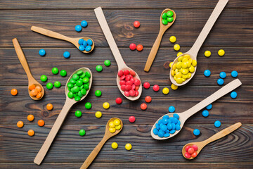 delicious colorful sweet candies on spoon on colored background . Confectionery decor top view with copy space