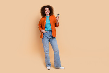 Full length photo of adorable girl dressed stylish clothes modern gadget apple iphone empty space...