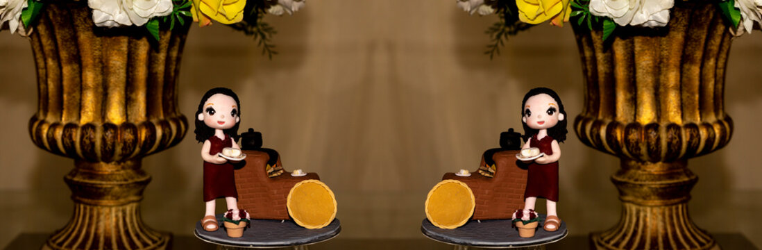 Decora&ccedil;&atilde;o de mesa de anivers&aacute;rio com boneca e jarro dourado.