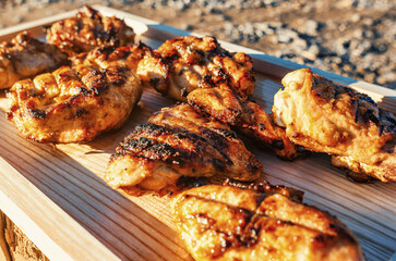 Glorious Sunlit Setting for Sizzling Grilled Chicken Portions on Rustic Wooden Surface