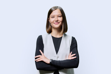 Young confident successful woman with crossed arms on white background