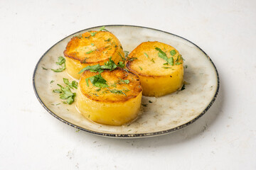 Potato fondant in a plate, on a light background, tender tasty potatoes