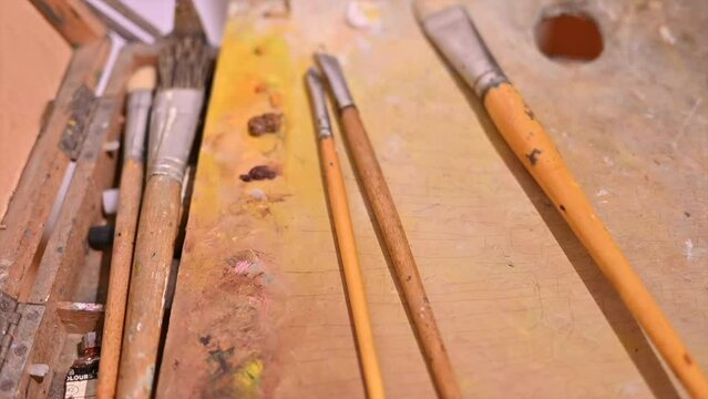 Brushes for paintings lying on a wooden underlay