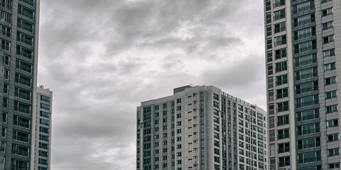 흐린 날씨의 회색 건물들 사이로 보이는 구름
