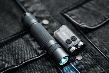 Pocket flashlight for Everyday Carry (EDC) on a dark background. Ray of light.	
