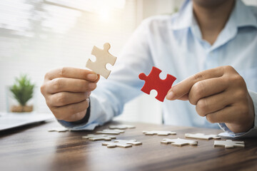 person hand connecting jigsaw puzzle pieces, business solutions, goals, success, goals and strategy concept, teamwork concept.