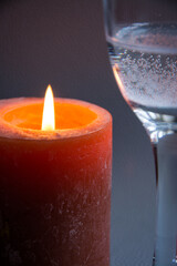 
Large burning candle with a glass, romantic evening