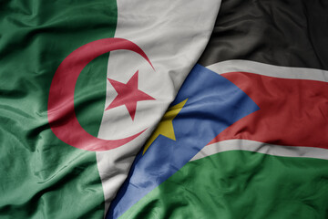 big waving national colorful flag of algeria and national flag of south sudan .