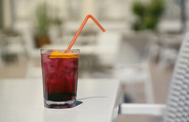 Pink and red Fresh colorful exotic alcoholic cocktail with lemon and ice on restaurant table. Colorful pink Soft drink with ice. Red colorful Mojito