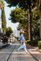 Tourist woman in the city center of Antalya Turkey, palms around, tramway in background; summer day.