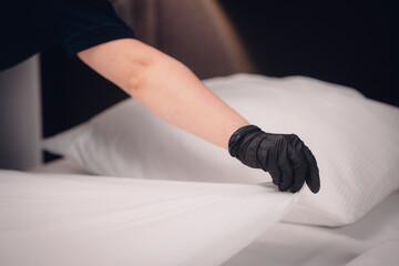 Reinigungskraft macht die Betten im Hotelzimmer