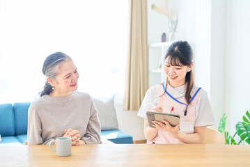 Fototapeta premium 会話するシニア女性とエプロン姿の若い女性