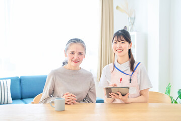 会話するシニア女性とエプロン姿の若い女性