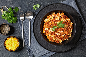 Lasagnette bolognese in black bowl, top view