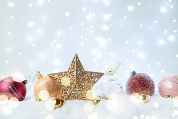 Fototapeta na wymiar White christmas with snow - pink and golden decorations with stra over festive bokeh lights