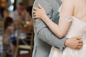 A newlywed couple holding each other during their first dance as a family.