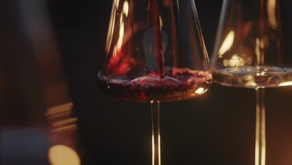 Red wine being poured into a wine glass with beautiful mountains at sunset background. Romantic dinner with wine and food by the vineyards. Close-up shot of wine bottle pouring deep red wine, creating - Powered by Adobe