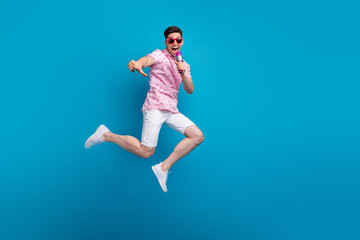 Fototapeta na wymiar Full length photo of overjoyed nice person jump sing microphone empty space isolated on blue color background