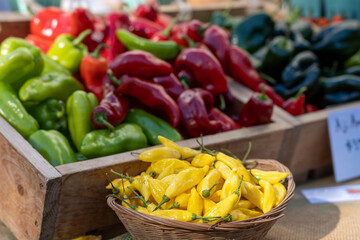 Fresh pepper for sale in a wooden box at a local farmers market in the fall