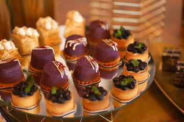 Sweet cakes with filling laid out on a glass stand.