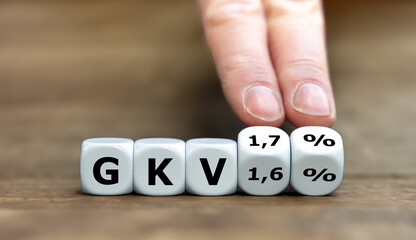 Hand dreht Würfel und ändert des Ausdruck 'GKV 1,6 %' in 'GKV 1,7%'. Symbol für die Anhebung des Krankenkassen-Zusatzbeitrag um 0,1 Prozent in Deutschland. 