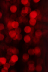 Defocused red holiday bokeh background. Red lens flare Christmas and New Year lights.
