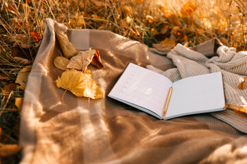 Paper planner on blanket outdoors, autumn concept