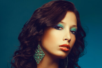 Epoque of Disco concept. Close up portrait of fashion model with curly hair and arty make-up posing...