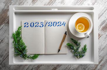 Numbers 2023-2024 in a notepad. Still life on a tray table.