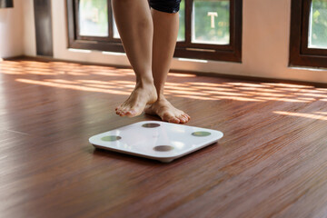 Fat diet and scale feet standing on electronic scales for weight control. Measurement instrument in...