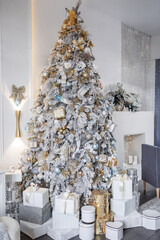 Large luxury design snowed Christmas tree with lights and balls in beige, brown, gold, silver colors, Christmas gifts living room, decoration with fireplace. Concept happy christmas, boxing day