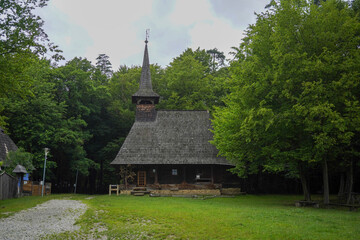 Fototapeta na wymiar Old wooden church surrounded by trees in Romania