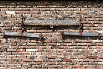 Old wooden harness or seesaw on the brick wall of farm backyard as decoration, parts of an old...