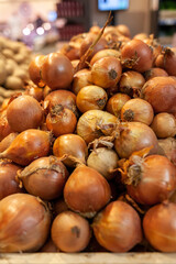 Fresh onions on the market close up photo. Onions big Golden on the counter market. Buying vegetables and food for cooking.