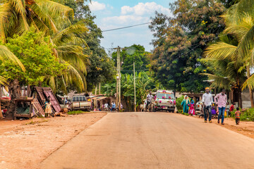 African road through village people going about business