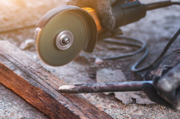 A worker sharpens scrap steel using an angle grinder. Restoring a dull tool at the workplace. Close...