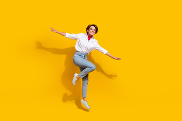 Fototapeta na wymiar Photo of optimistic cheerful funky girl wear trendy clothes flying air rejoicing having fun v-sign isolated on yellow color background