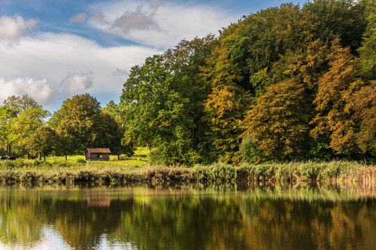 Herbstandschaft im Freilichtmuseum Molfsee mit bunten Bl&auml;ttern und einem Teich
