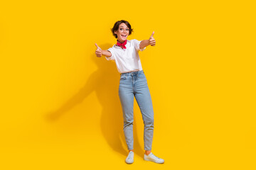 Full length photo of cheerful girl wear stylish white outfit showing thumbs up approval yes symbol isolated on yellow color background