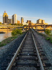 Fototapeta na wymiar Early morning cityscape of St Paul and Twin Cities in Minnesota looking down rails of railroad bridge