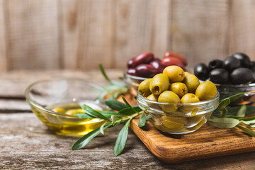A set of green, red and black olives on  background. Various types of olives in bowls and fresh...