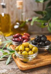 A set of green, red and black olives on  background. Various types of olives in bowls and fresh...